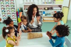 child care teacher and kids play at a table