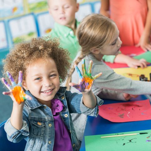 girl with finger paints on hands